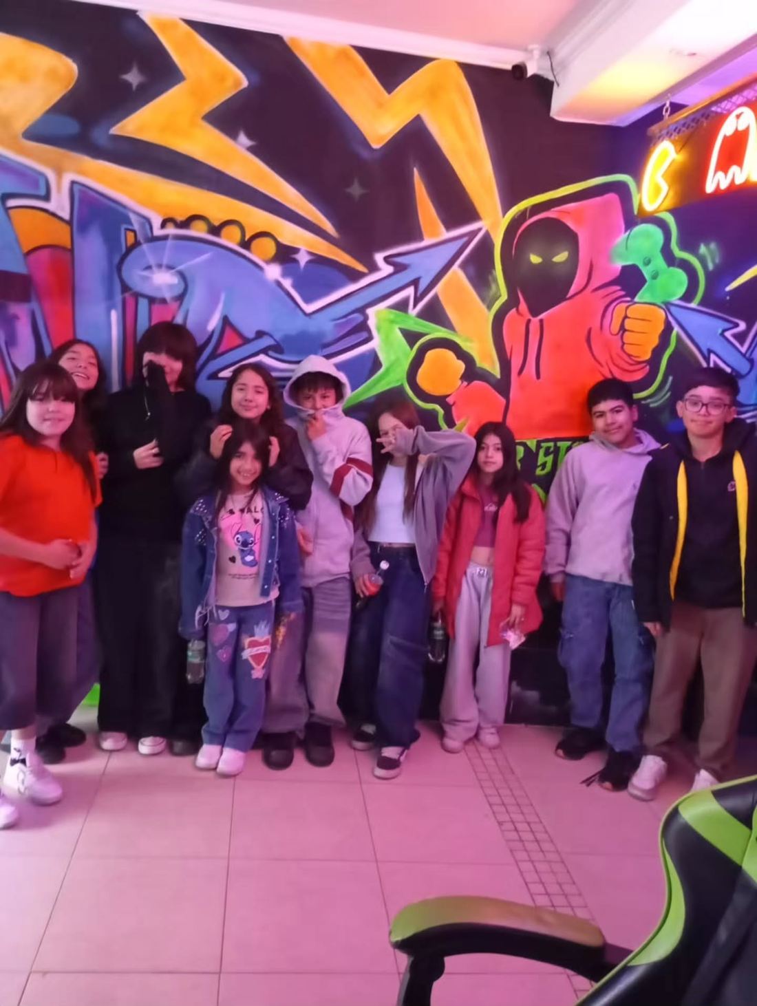Grupo de invitados posando frente a la pared de graffiti